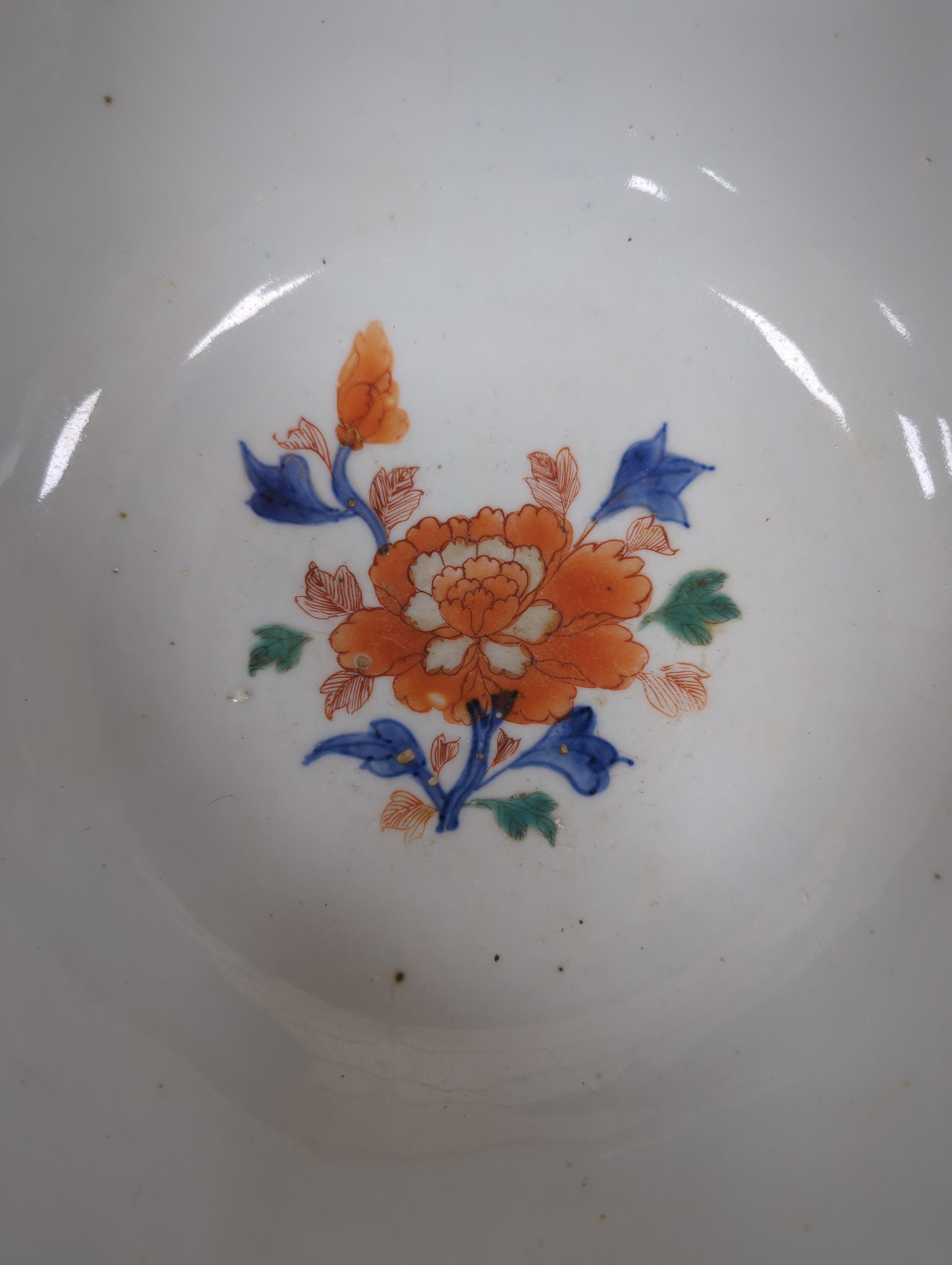 An 18th century Chinese famille rose bowl and a group of five Chinese wucai plates, each decorated with fruit, the bowl 23cm in diameter